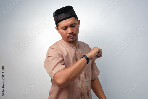 muslim man look into his watch photo