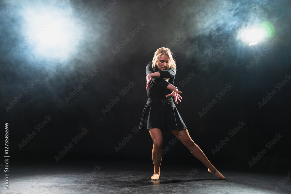 Contemporary woman dancer posing on black background with smoke. Adult female artist performer dancing with expression. Modern ballerina dancing in darkness. Passion dance in dark. Flexibility balance Contemporary woman dancer posing on black background with smoke. Adult female artist performer dancing with expression. Modern ballerina dancing in darkness. Passion dance in dark. Flexibility balance