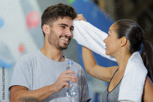 woman wiping the sweat of her wall climber boyfriend photo