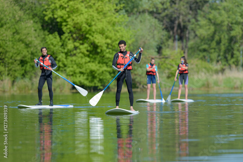 group of people stand up paddleboarding photo