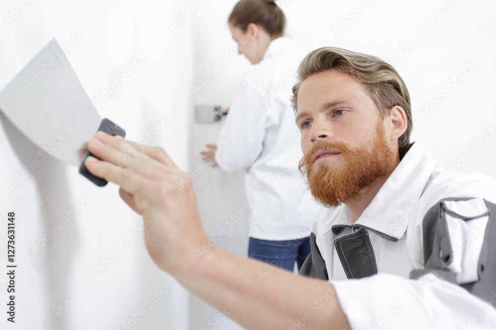 man spreading paint on wall man spreading paint on wall