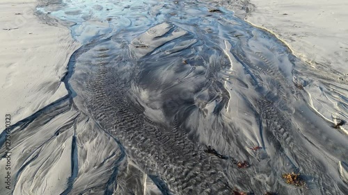 Natural watercourse, also known as a tidal creek, at Skagsanden Beach in Flakstad. Lofoten district in Norway 