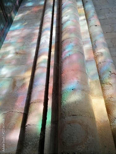 rainbow lighting shining across old stone walls in church