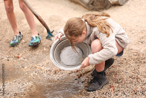 Kids panning for gold in shallow creek