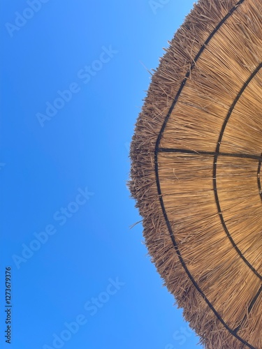 straw umbrella on a blue sky background