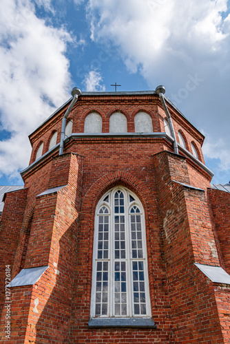 red brick wall with white windows of a historic church, reverse