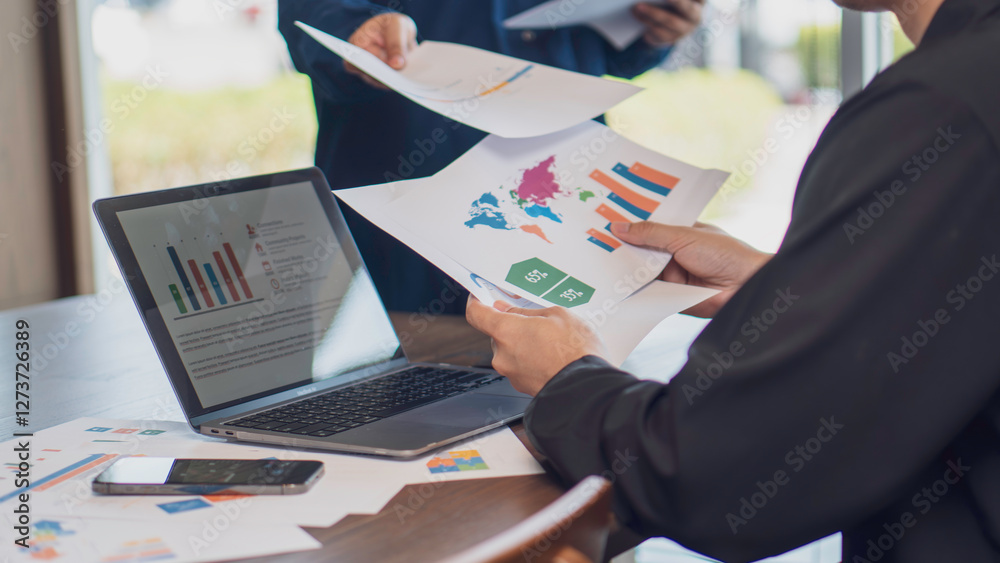 business collaboration, teamwork, and data analysis, featuring handing over a financial report with charts and graphs to a colleague in an office. business strategy, financial planning professional