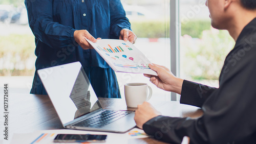 Obraz na płótnie business collaboration, teamwork, and data analysis, featuring handing over a financial report with charts and graphs to a colleague in an office. business strategy, financial planning professional w salonie