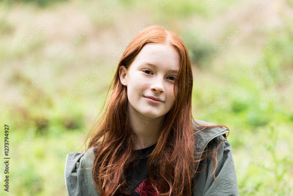 Red haired twelve year old girl with freckles posing with a nature bokeh background Red haired twelve year old girl with freckles posing with a nature bokeh background
