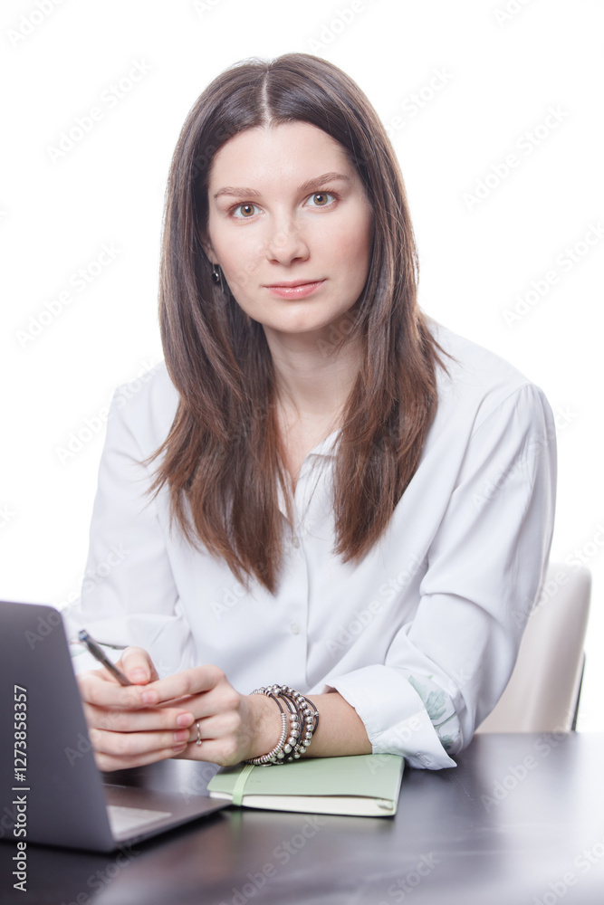 Portrait of an attractive young businesswoman working on her laptop while sitting in the office on a white background. Selective focus