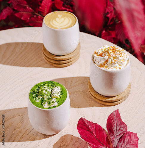 Colorful coffee drinks on a wooden table with autumn leaves photo