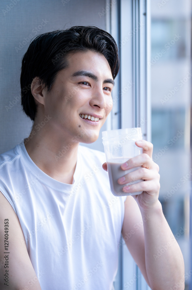 ジムでプロテインを飲むタンクトップの日本人男性 ジムでプロテインを飲むタンクトップの日本人男性