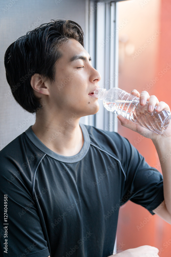 ジムで水を飲む日本人男性