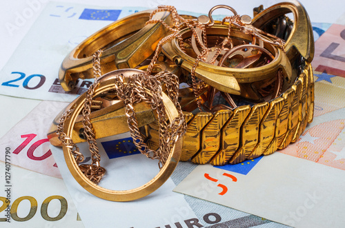 A scrap of gold. Old and broken jewelry, watches of gold and gold-plated gold plated wristwatch housing on a background of Euro banknotes..