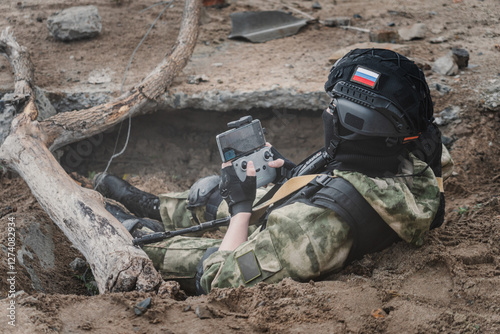 Bild auf Leinwand UAV operator with a remote control sitting in a trench