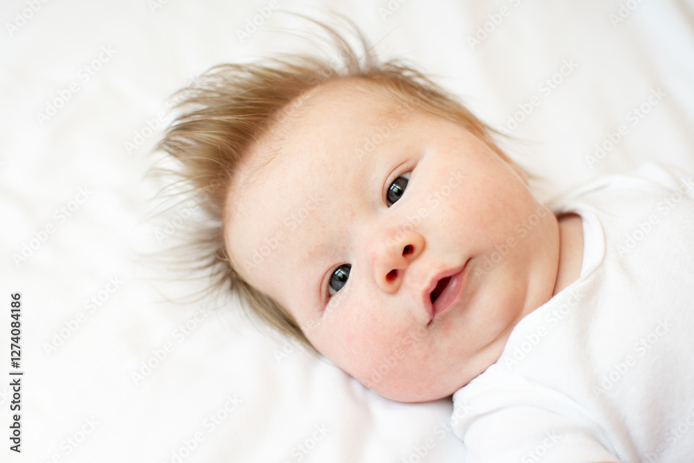 Portrait of an alert cute Caucasian newborn baby girl looking at the camera Portrait of an alert cute Caucasian newborn baby girl looking at the camera