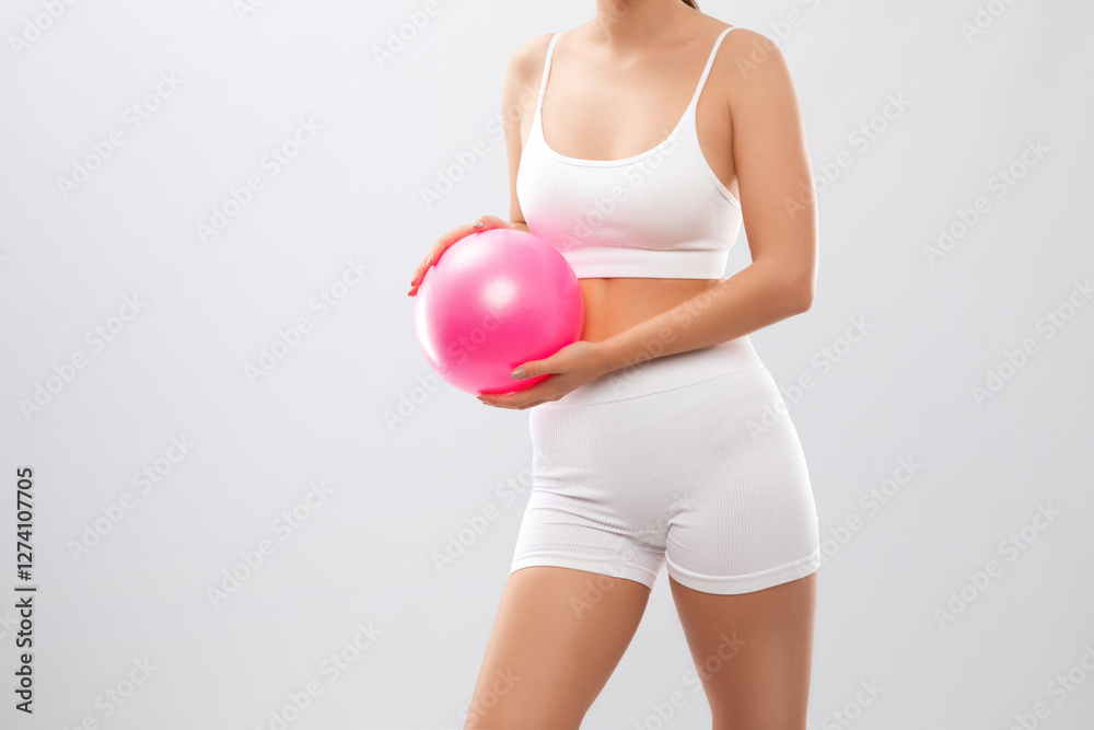 Beautiful attractive girl in white shorts and a top with a Pilates ball on a white background. The concept of sports and healthy lifestyle. Beautiful attractive girl in white shorts and a top with a Pilates ball on a white background. The concept of sports and healthy lifestyle.