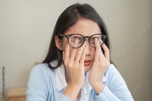 woman taking off glasses tired of computer work suffering from eye strain tension photo