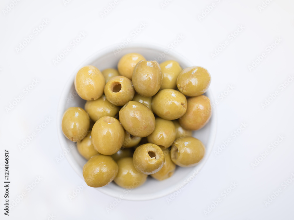 pitted green olives in bowl on white background pitted green olives in bowl on white background