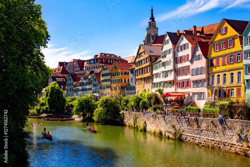 Tuebingen popular university town in southern Germany. “Neckarfront“ with colorful facades, church (Stiftskirche) and poled boats (Stocherkahn) on the River Neckar on a sunny summer day. 