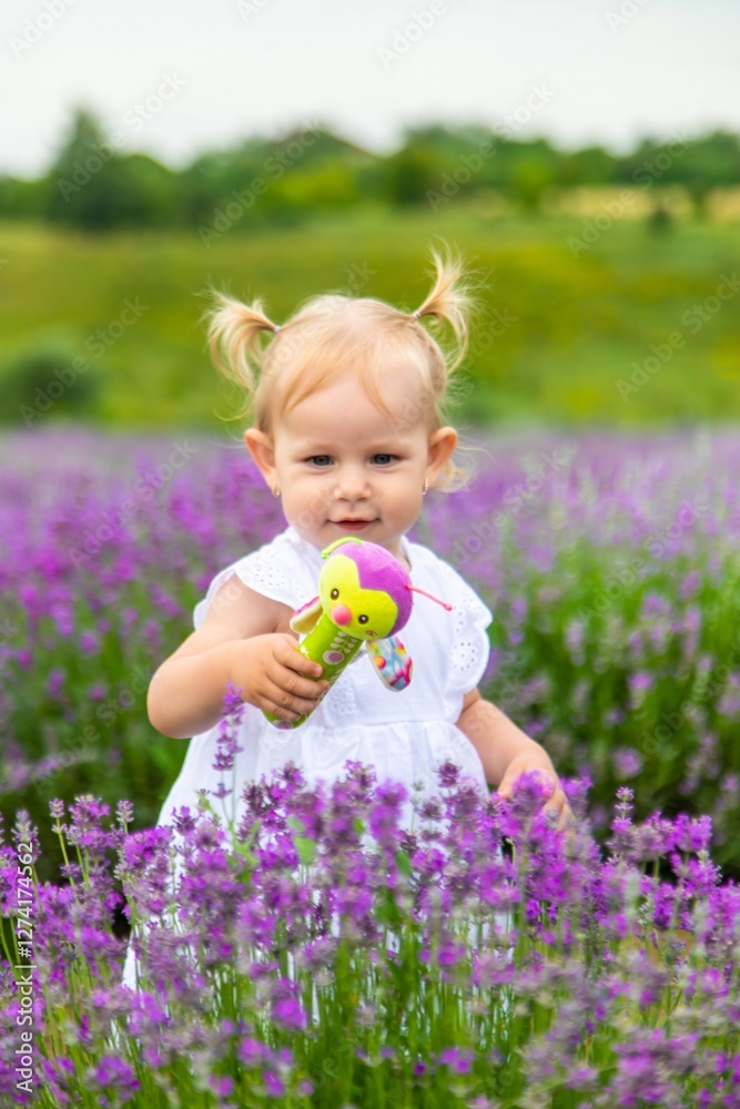 Little girl in a lavender field and touching the flowers with her hand.