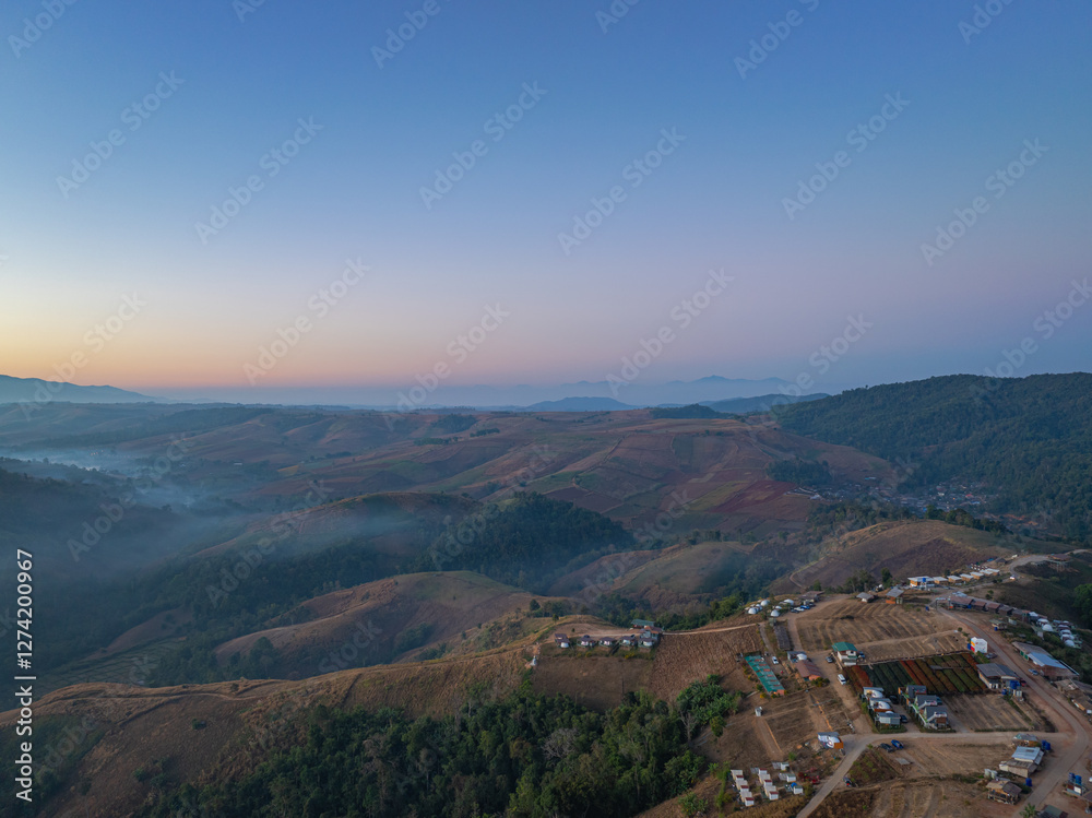 Fototapeta premium Aerial View of An image of sweet sky in sunrise above a valley of mist. High peaks wonderful morning sunrise nature Landscape. Beautiful sunset tropical landscape background.
