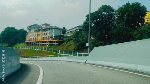 A view of a left corner turn leading down a flyover, showcasing the road below and surrounding cityscape.