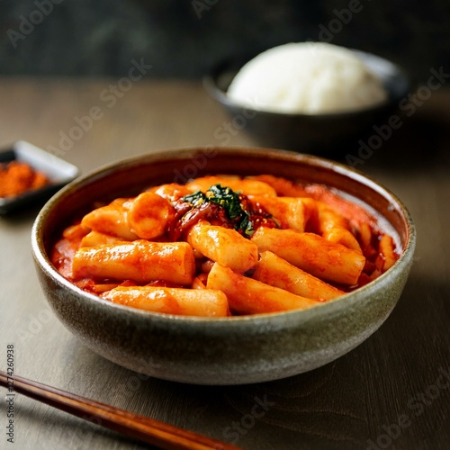 Authentic Korean Tteokbokki in Spicy Gochujang Sauce – Chewy Rice Cakes in Rich, Deep-Red Chili Paste, Served Hot in Rustic Ceramic Bowl – Traditional Korean Street Food, Perfect for Comfort Flavor photo