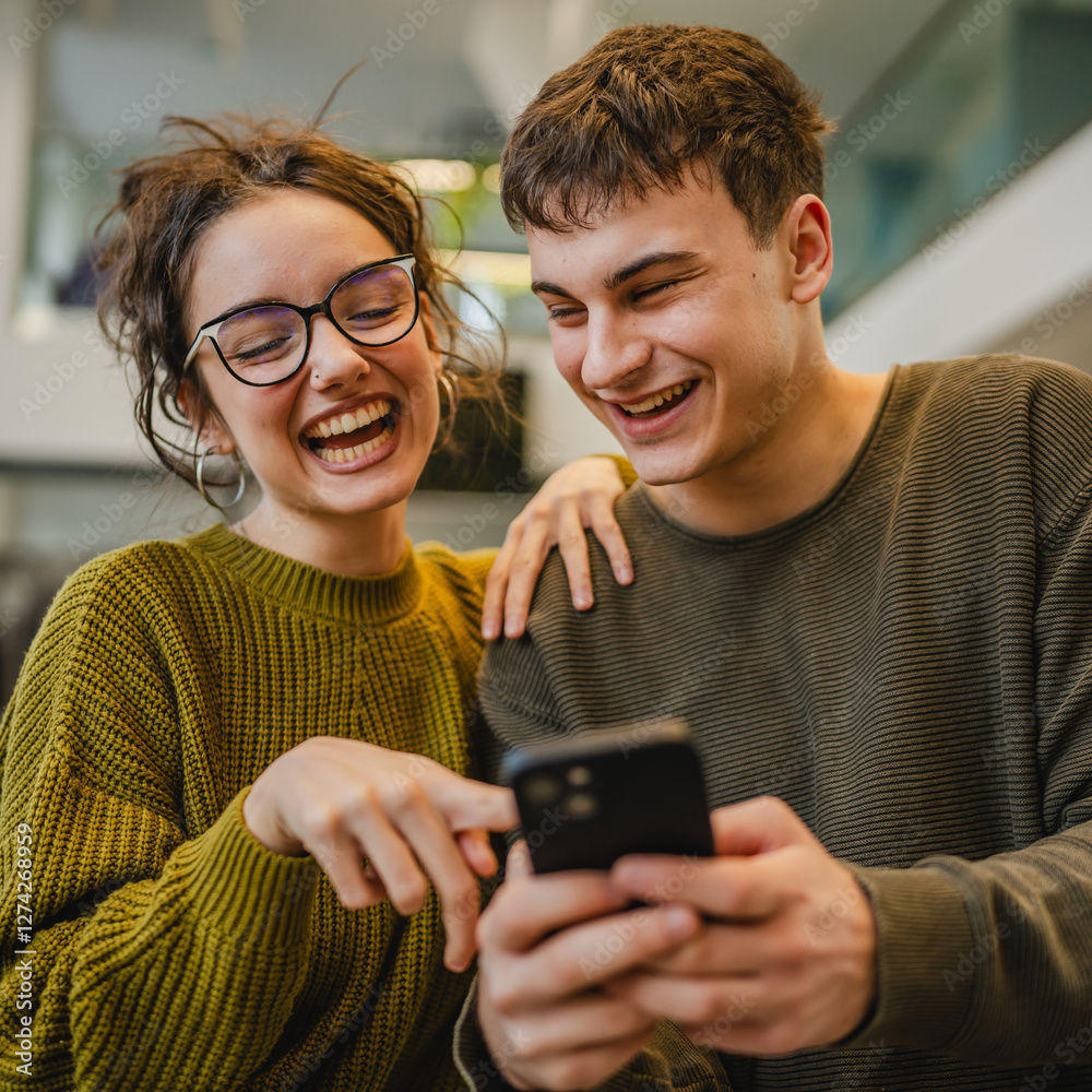 Fototapeta premium happy excited young couple use cellphone in the modern cafe