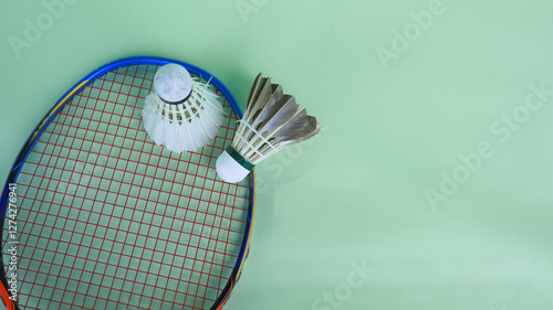 White badminton shuttlecocks and badminton rackets on green background