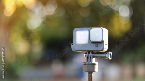 Action camera on its handle on blur background