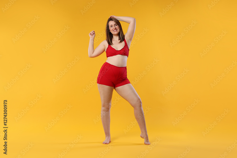 Woman in red underwear on orange background. Cellulite problem Woman in red underwear on orange background. Cellulite problem