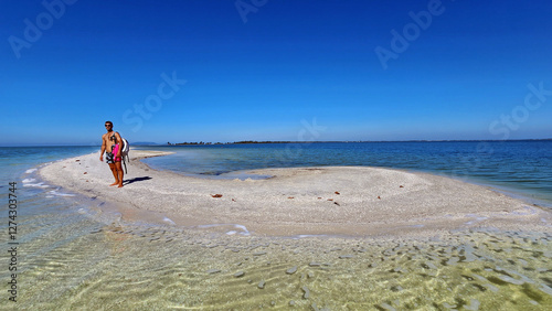 Chico caminando por extraña saliente de arena blanca en Arubinha, Cabo frío, Brasil