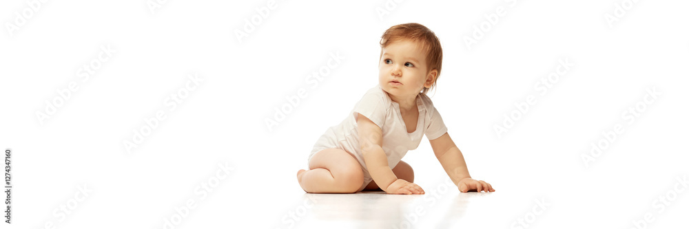 Banner. Baby in onesie, sitting with one hand on floor and head turned to side against white background with negative space to insert text. Concept of childhood, observation, adaptability, perception. Banner. Baby in onesie, sitting with one hand on floor and head turned to side against white background with negative space to insert text. Concept of childhood, observation, adaptability, perception.