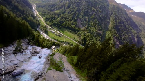 Stunning aerial view of a waterfall cascading down mountains with lush greenery in the background