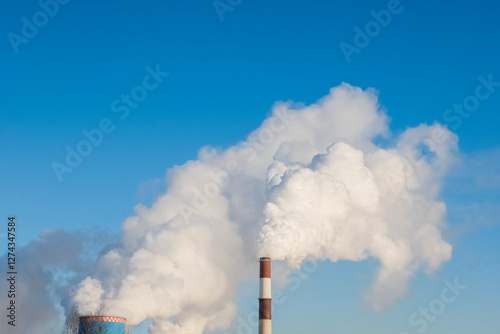 environmental pollution theme: smoking chimneys of thermal power plant against blue sky