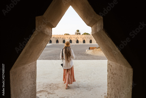 Принти на полотні Tourist woman walking into the historic courtyard of the qasr al hosn fort in ab
