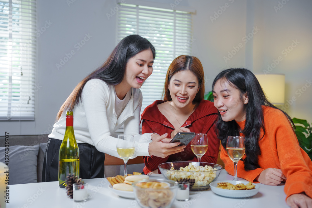 Asian women looking smartphone sharing social media content enjoying home party Asian women looking smartphone sharing social media content enjoying home party