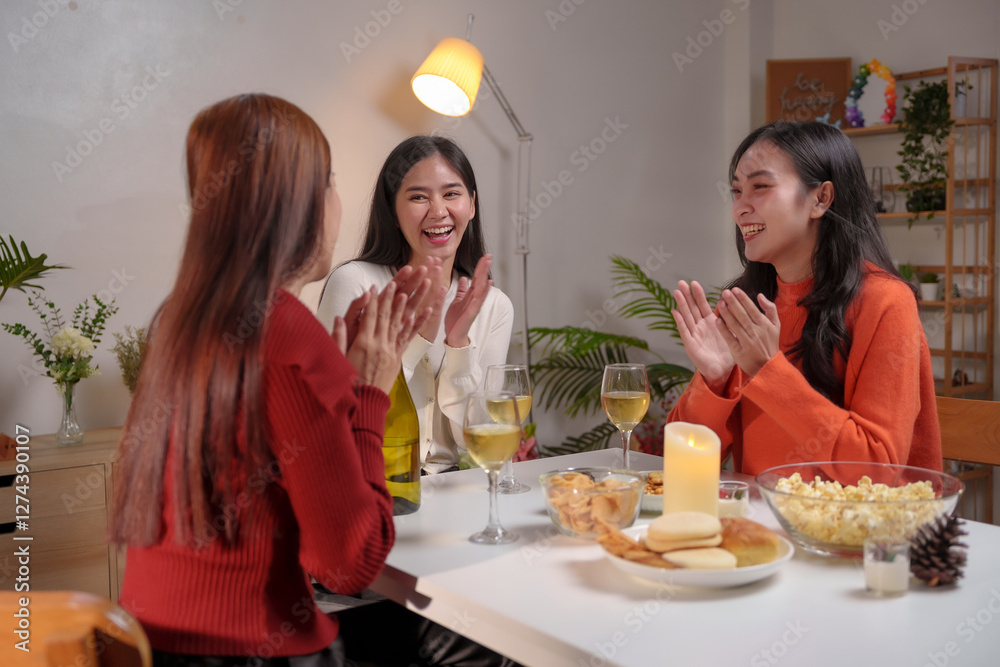 Happy asian women clapping hands and laughing during a home party Happy asian women clapping hands and laughing during a home party