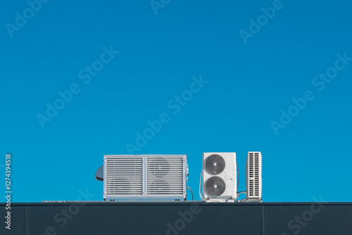 Air Conditioning Units on Modern Building Rooftop with Clear Blue Sky