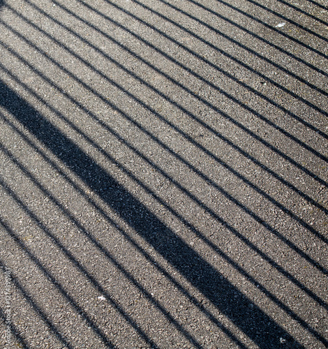 reflection of a fence on asphalt