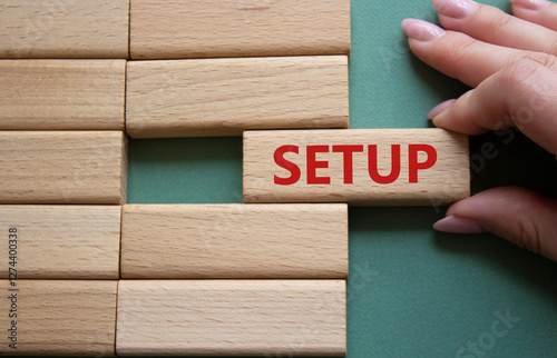 Setup symbol. Wooden blocks with word Setup. Businessman hand. Beautiful grey green background. Setup concept. Copy space.