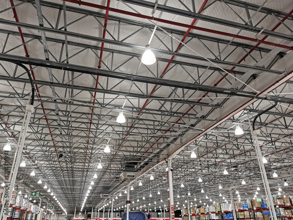 Large warehouse illuminated with numerous lights and a multitude of spotlights on the ceiling Large warehouse illuminated with numerous lights and a multitude of spotlights on the ceiling