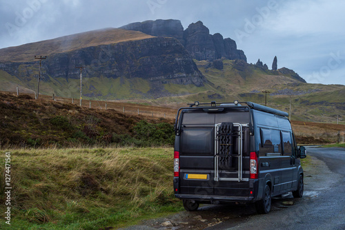 Black campervan overnight parking besides a road on the Isle of Skye with Old man of Storr in the background, Scotland