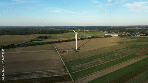 Wind turbine on farmland during sunset