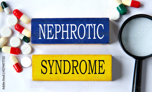 NEPHROTIC SYNDROME - words on a wooden blue block on a background of pills