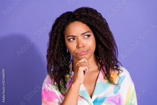 Φωτογραφία Thoughtful young woman with curly hair pondering against a vibrant purple backgr