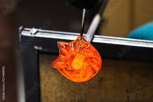 Foto Sculpting molten glass into a flower shape, glass blowing