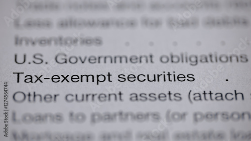 Close-up of a document showing financial items like tax-exempt securities, U.S. government obligations, inventories, and other current assets on a white page. photo