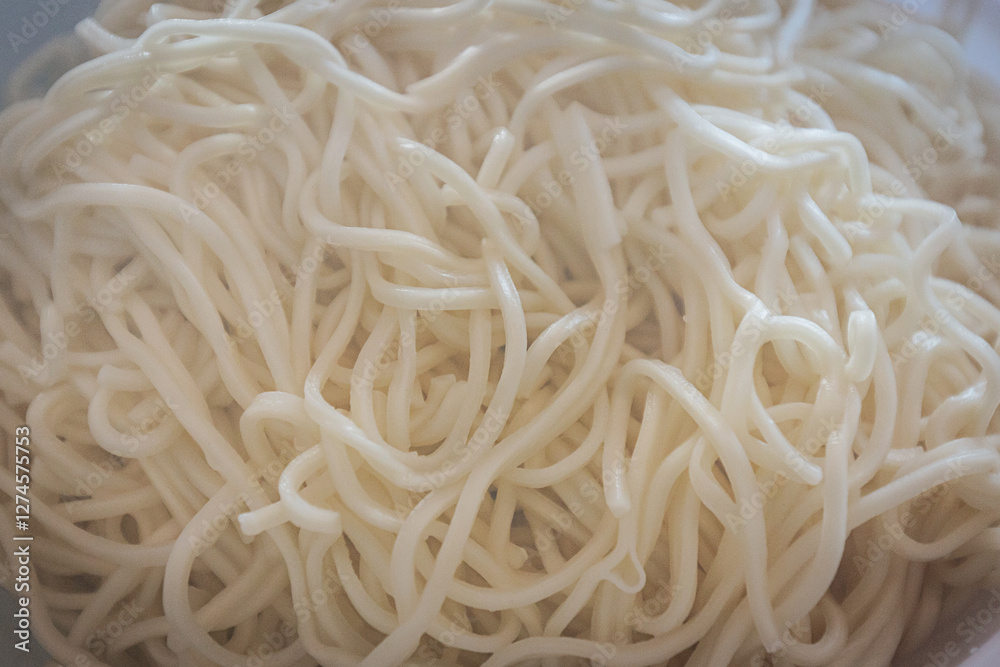 A close-up of freshly cooked noodles in a white bowl. The soft, slightly glossy texture highlights their perfect preparation, ready to be served or mixed with other ingredients. A close-up of freshly cooked noodles in a white bowl. The soft, slightly glossy texture highlights their perfect preparation, ready to be served or mixed with other ingredients.